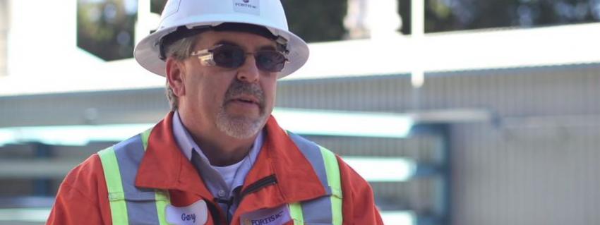 Man wearing a hard hat, sunglasses and a safety vest