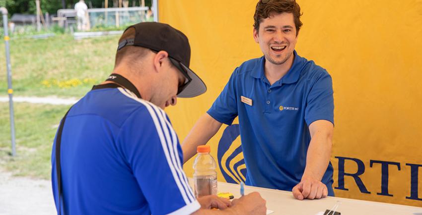 FortisBC team member helps a man filling out a ballot at the Great Salmon Send-Off