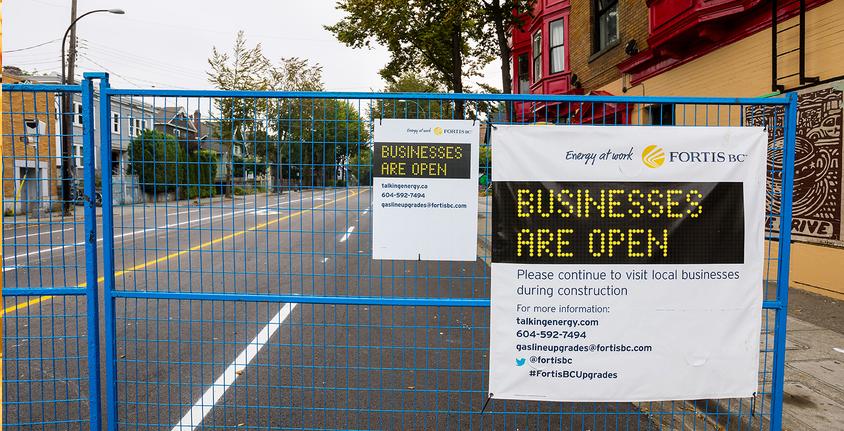 Businesses are open sign on construction fence