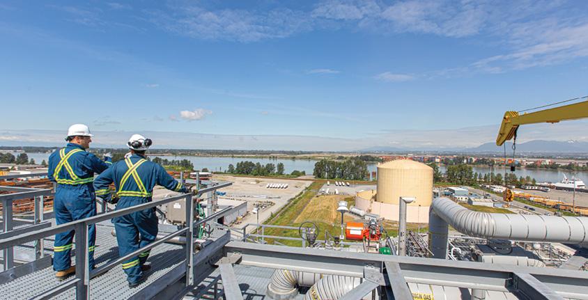 Two men stand on a platform overlooking the Tilbury LNG facility