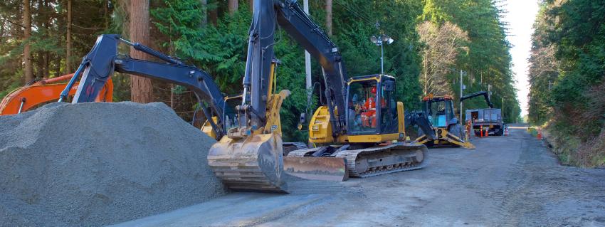 Excavators beside a large pile of gravel