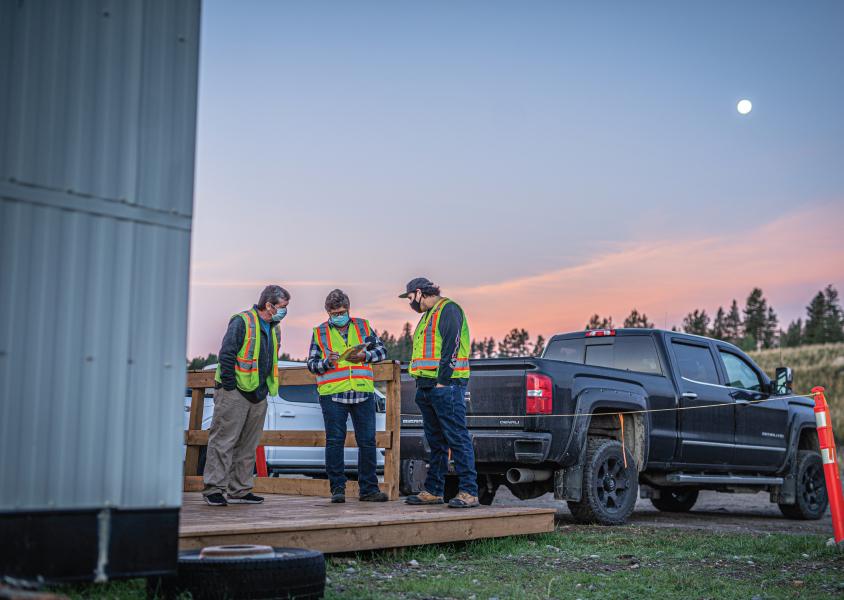 Karen Barton reviews the day’s work schedule with Randy Loski and Shane Gravelle 