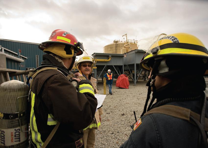 Firefighters stand outside the Tilbury LNG facility