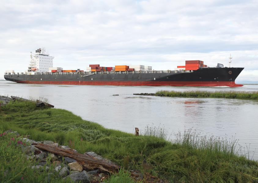 LNG cargo ship anchors in the harbour, as seen from the shore