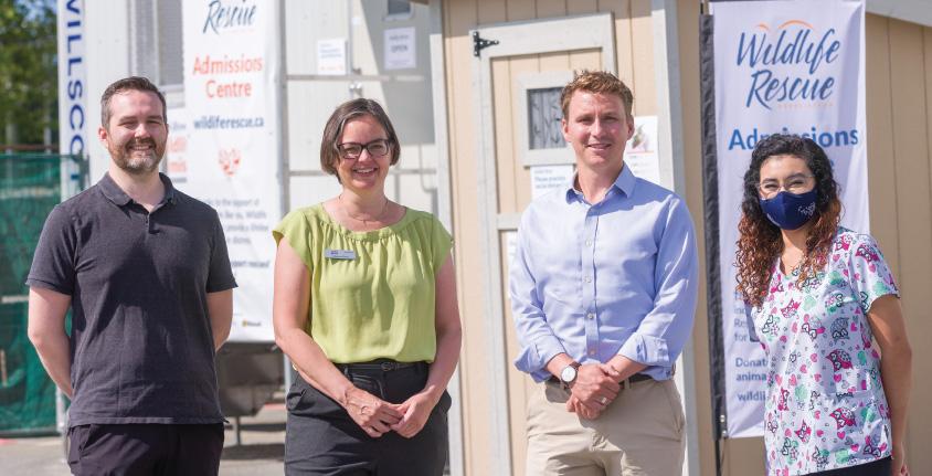 four people stand outside the Wildlife Rescue centre, smiling at the camera