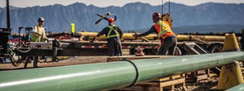 green gas pipeline with workers in the background